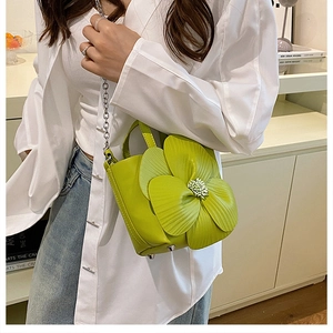 Detail of bright green petal bucket bag with 3D floral design and silver chain strap