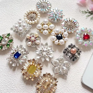 Flat lay of luxury diamond and pearl encrusted phone grips in various jewel tones