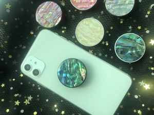Detail showing colorful shell texture phone grip on a smartphone with starry background