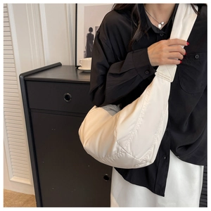 Détail d'un sac à bandoulière matelassé blanc en forme de croissant au style bouffant