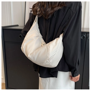 Détail d'un sac à bandoulière rembourré blanc crème avec texture en nylon brillant