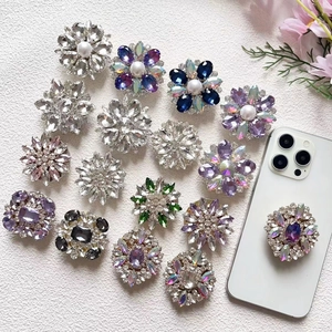 Close-up of luxury crystal flower phone grips with shimmering rhinestones and pearls