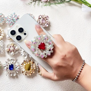 Luxury heart-shaped diamond phone socket grip with colorful rhinestones on white smartphone
