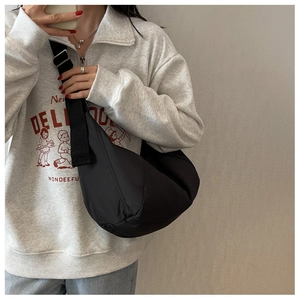 Détail d'un sac bandoulière demi-lune noir avec sangle réglable via un selfie miroir
