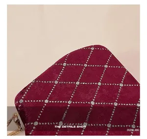 Gros plan sur tissu matelassé bordeaux avec broderies florales blanches délicates