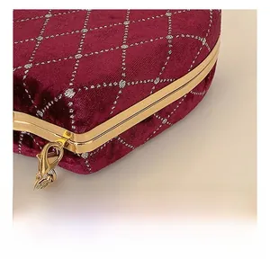 Vue détaillée du sac en velours rouge avec broderies dorées et crochet en métal