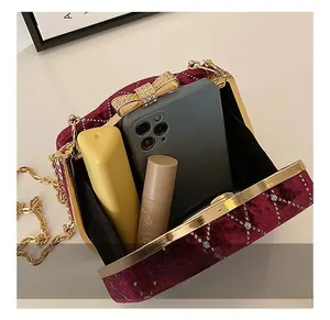 Capacité interne du sac boîte en velours bordeaux montrant l'espace pour maquillage