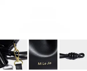 Détails du crochet doré, du logo estampillé et du cordon en cuir noué sur le sac noir