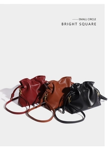 Détail des sacs seaux plissés en bordeaux, caramel et noir avec des garnitures dorées chic