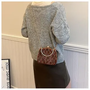Sac boîte vintage matelassé avec détails perles et chaîne en métal porté par un mannequin