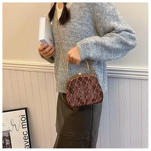 Détail du sac boîte en velours marron avec surpiqûres matelassées et perles blanches
