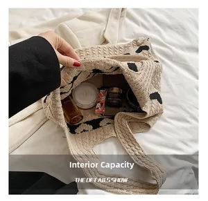 Macro shot showing internal capacity of heart pattern knit tote with phone and cosmetics