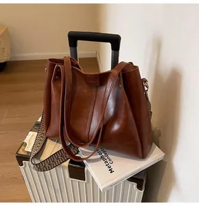 Detail der braunen Vintage-Tasche mit strukturiertem Leder und gewebtem Muster-Schultergurt
