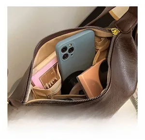 Innenansicht der braunen Handtasche mit beigem Futter und praktischen Fächern