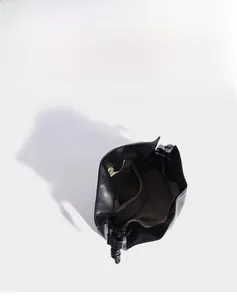 Vue détaillée de la structure interne du sac seau en cuir noir avec fermeture aimantée