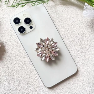 Detailed macro view of a pink and white crystal flower griptok on a white phone