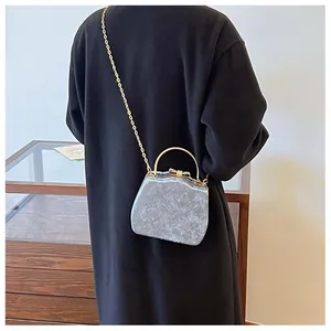 Vue arrière d'un mannequin portant un sac matelassé gris clair avec bandoulière dorée