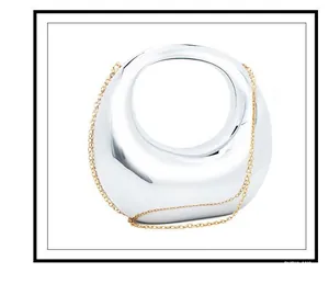 Detailed macro view of mirror silver handbag with sleek metallic finish and gold chain