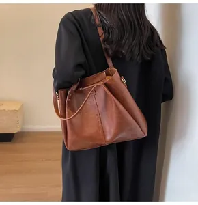 Detailaufnahme einer braunen Vintage-Einkaufstasche mit strukturierter Oberfläche und Trageriemen
