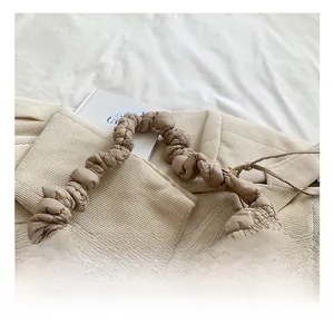 Detailed close-up of quilted beige puff shoulder bag with soft pleated handle texture