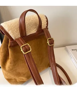 Dettaglio degli spallacci regolabili in pelle su uno zaino vintage in pelle scamosciata