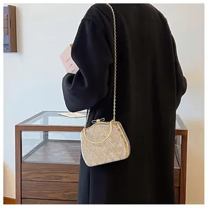 Détail du sac bandoulière matelassé or champagne avec poignée métallique et chaîne