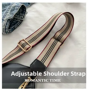 Adjustable beige woven shoulder strap with black stripes and gold-toned metal buckle