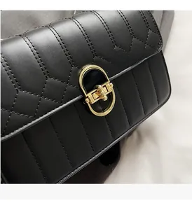 Detailansicht einer schwarzen gesteppten Ledertasche mit goldenem ovalem Drehverschluss