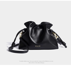 Détail du sac seau en cuir plissé noir avec finitions dorées et logo de la marque