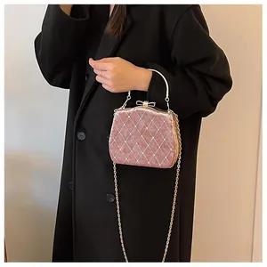 Sac à main rose matelassé avec poignée en métal doré et fermoir nœud porté par un mannequin