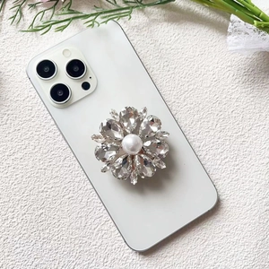 Detailed view of luxury flower shape phone grip with rhinestones and white pearl center