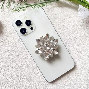 Macro view of luxury floral diamond phone grip with sparkling crystals on a white phone