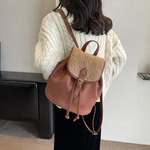 Dettaglio di zaino vintage in pelle scamosciata marrone con bordo in lana d'agnello