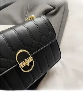 Nahaufnahme der schwarzen gesteppten Ledertasche mit goldenem Schloss und Kettenriemen