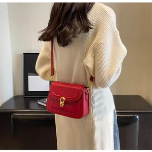 Detailed back view of a red leather square crossbody bag with gold twist lock