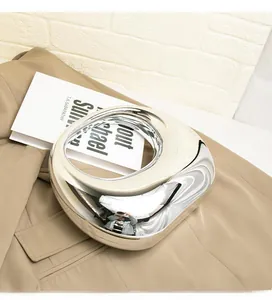 Detailed close-up of a silver acrylic clutch with a high-shine mirrored finish