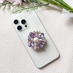 Macro detail of luxury flower phone grip with crystal rhinestones and central pearl