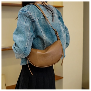 Rückansicht eines Models mit der braunen halbmondförmigen Ledertasche mit Trageriemen