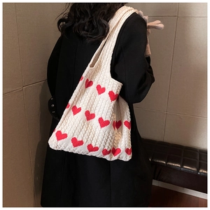 Close-up of knit tote bag showing soft woven texture and red heart jacquard pattern