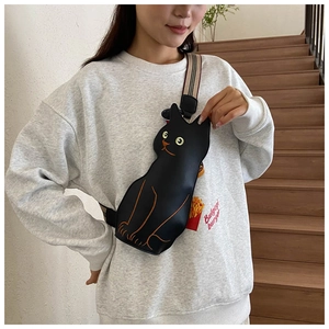 Detail of creative black cat chest bag with striped strap and embroidered cartoon face
