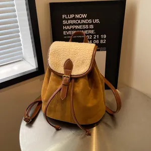 Dettaglio di zaino vintage in pelle scamosciata con patta in agnello e finiture in pelle