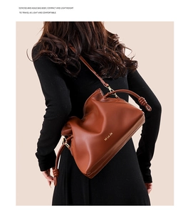 Sac seau en cuir marron avec détail de nœud et finitions dorées porté par un modèle