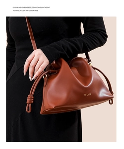 Détail du sac seau en cuir marron caramel avec cordon de serrage et lettrage doré