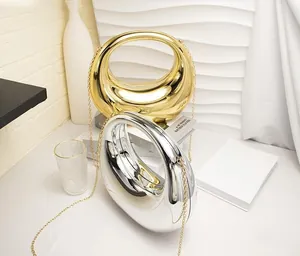 Detail of egg-shaped acrylic evening bags in gold and silver with metallic chain