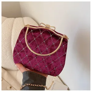 Détail d'un sac en velours bordeaux avec matelassage en losange et nœud en cristaux