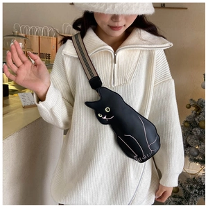 Detail of cute black cat silhouette shoulder bag with striped strap on a model