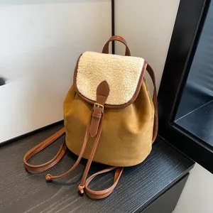 Dettaglio dello zaino in pelle scamosciata marrone con bordo in pile bianco e fibbia in metallo
