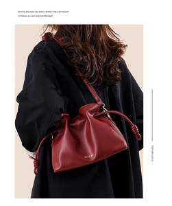 Détail d'un sac seau bordeaux avec cordon à nœud porté par un mannequin de dos