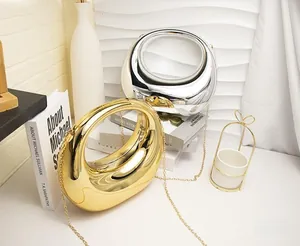 Close-up of minimalist gold and silver metallic crossbody bags with high-gloss mirror finish