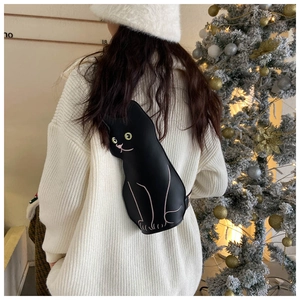 Detail of creative black cat crossbody bag with green eyes and pink embroidery
